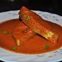 GOAN FISH CURRRY::__::<br /><br />What You'll Need<br />2 pounds (or about 1 kilogram) fish cleaned and cut into pieces (kingfish, monkfish, halibut or tuna)<br />1 1/2 inch lump of tamarind (lump tamarind can be found in Indian food specialty stores)<br />1/2 cup hot water<br />1 large onion sliced<br />1 large tomato sliced<br />7 to 8 dry red chilies<br />2 tablespoons garlic paste<br />1 tablespoon ginger paste<br />1 1/2 cups grated fresh coconut<br />2 tablespoons coriander powder<br />2 tablespoons cumin powder<br />1/2 teaspoon turmeric powder<br />1/2 teaspoon red chili powder<br />2 green chilies slit<br />2 tablespoons vegetable cooking oil<br />Hot water for gravy (approximately 2 cups)<br />Salt to taste<br /><br />How to Make It<br />Soak the tamarind in 1/2 a cup of hot water for 10 minutes. Now mash the tamarind with your fingers to mix it well into the water. Strain through a sieve to extract all the pulp. Keep pulp aside.<br />Put the onion, tomato, coconut, ginger, garlic, dry red chilies, all the spices and the tamar+ind pureé into your food processor and grind well to make a smooth paste (masala).<br />Heat a deep pan on medium flame, then add the oil.<br />Add the green chilies and masala paste you just ground to the oil and fry for 5 minutes.<br />Now add the 2 cups of water (add more water if you would like more gravy) and bring the gravy to a boil. Reduce the flame to a simmer and cook for 10 minutes. Add salt to taste.<br />Gently add the pieces of fish to the gravy and cook for 10 more minutes. Do not cover the pan at any time during the cooking process.<br />Turn off the fire and serve immediately with plain boiled rice.<br />Cooking Tips and Ingredient Storage<br />Fresh spices are the cornerstone of making the best Goan food, or any Indian food for that matter. You may use a coffee grinder as a spice grinder, instead of buying spices that are already ground. By buying spices whole and grinding them as needed, your dishes will have a fuller flavor.